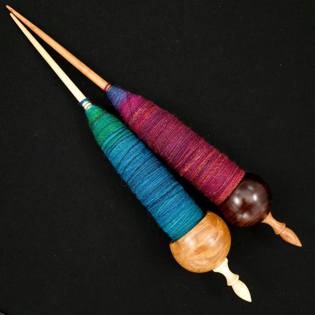 Two Spanish Peacock ninja spindles with spun fiber